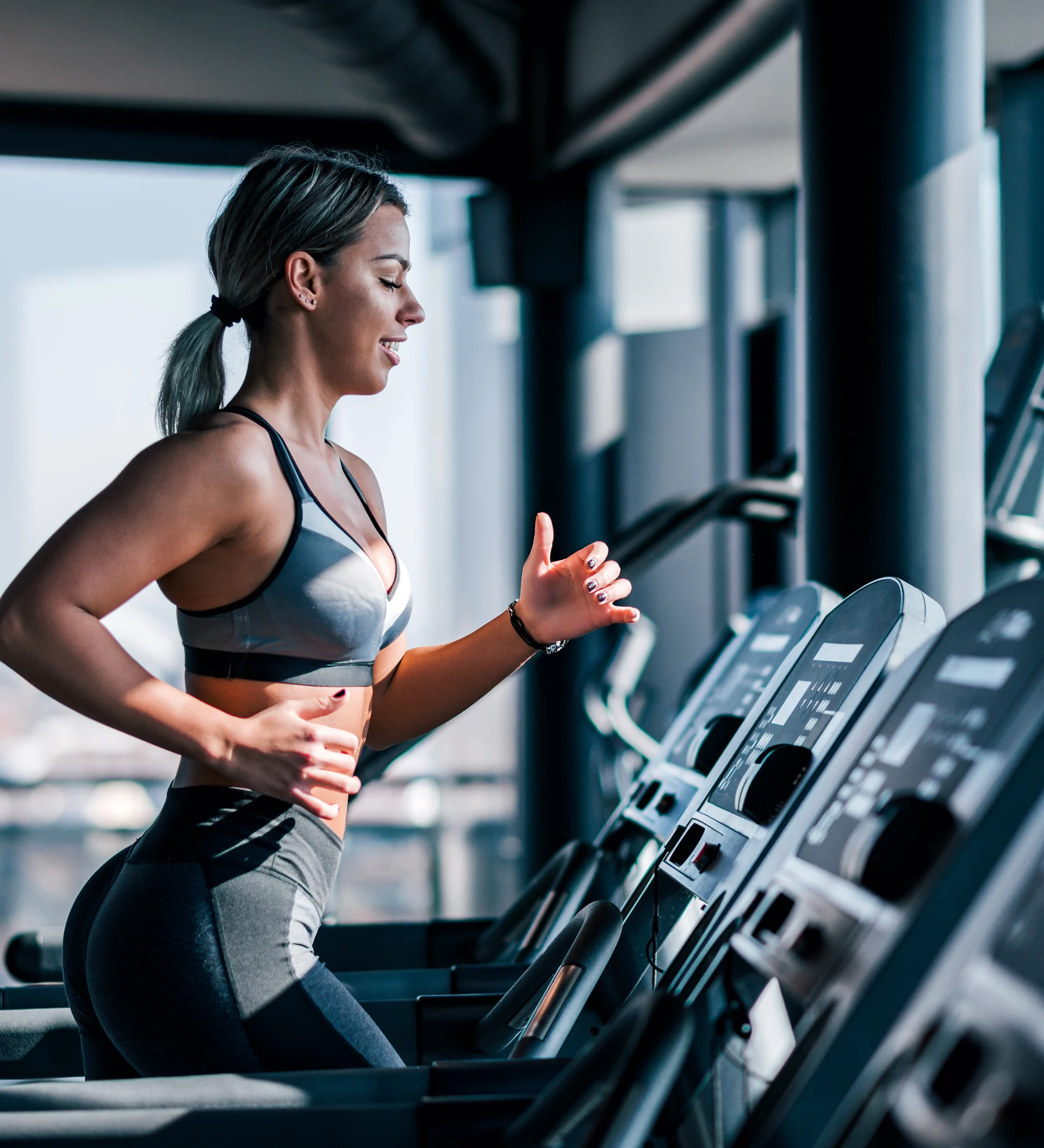 woman jogging on treadmill in fitness center